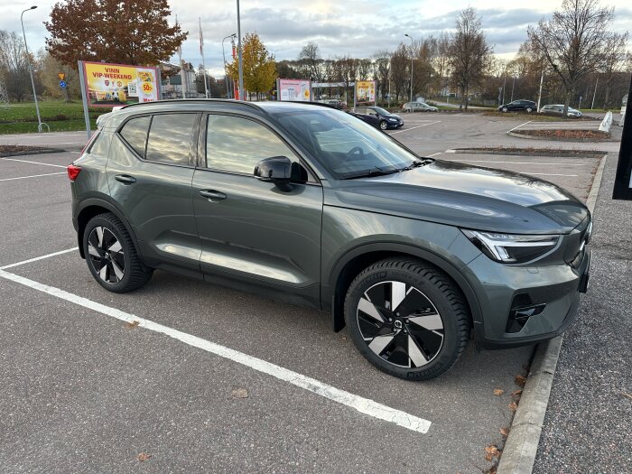 SUV parkerad på en asfaltparkering med vinterlandskap i bakgrunden, leasingbil EX40 efter 400 mil.