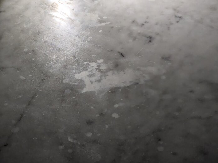 Marmoryta med ljusreflektioner och några fläckar.