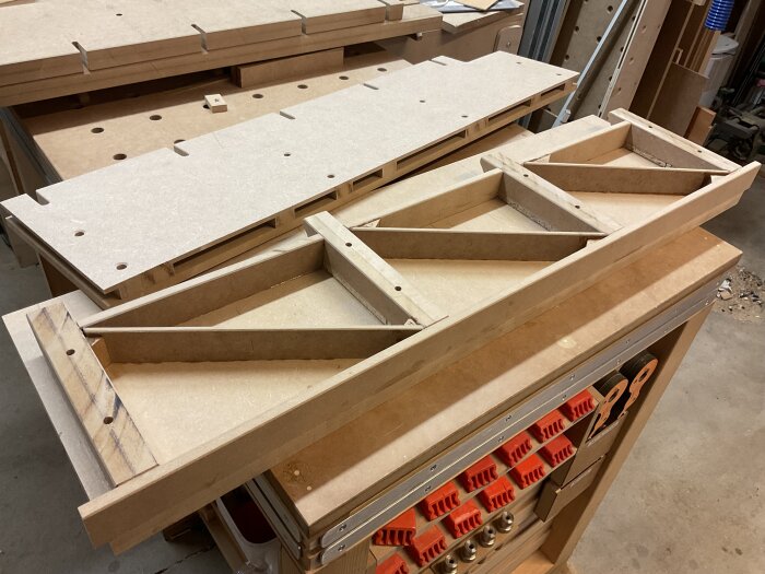 Högt anhåll till justersåg, byggt med torsion box-konstruktion, liggande på arbetsbänk i verkstad. Synliga vertikala och diagonala förstärkningar.