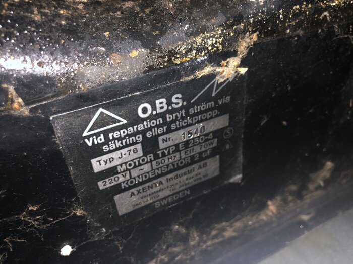 Etikett på en maskin med information om reparation och tekniska specifikationer, inklusive motortyp och spänning, från Axenta Industri AB.