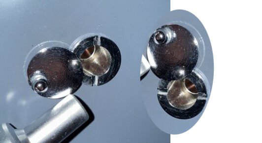 Närbild av ett dörrlås med två platta, runda låsplattor och ett metallhandtag ovanför.