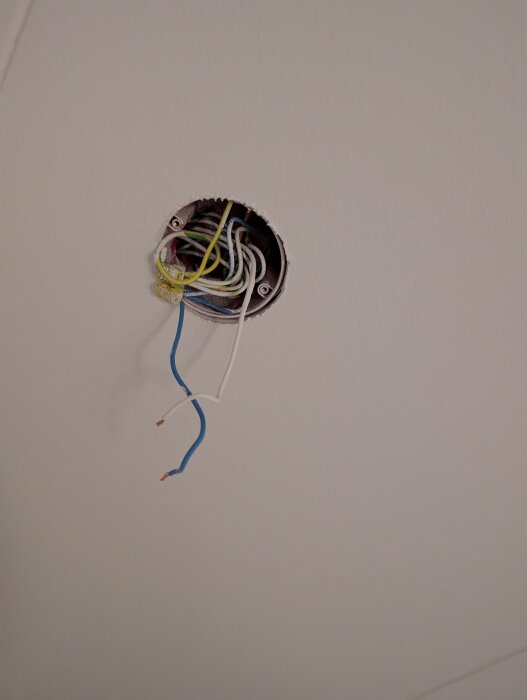 Lös och oskyddad elektrisk installation i taket med flera synliga kablar.