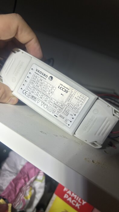 Närbild på Vadsbo LED-drivdon, modell LCC30, hålls i hand. Tekniska specifikationer syns på etiketten på enhetens ovansida.