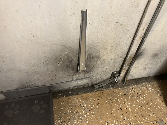 Dubbel källardörr med synligt mellanrum, potentiellt upp till 10mm, som kräver tätning och isolering. Dörren visar slitage och värmeläckage.