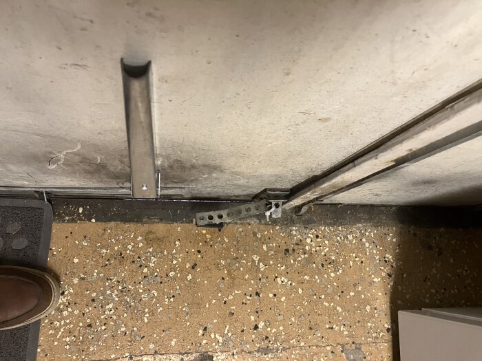 Dubbeldörr i källare med synliga glipor vid botten, golvet har stenmönster. Bild för diskussion om tätning och isolering.