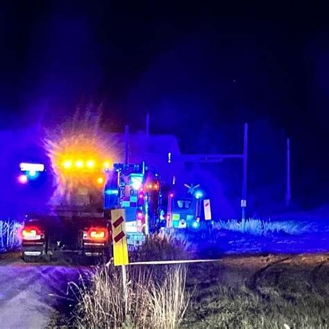 Utryckningsfordon med blåljus vid nattlig vägkant.