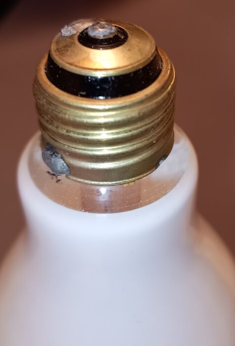 Glödlampa med tre kontaktpunkter i sockeln, kräver specialarmatur, närbild av metalldel och glas.