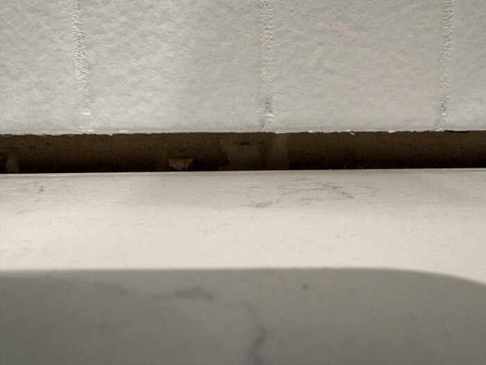 Glipa mellan stenskiva och vägg efter installation, med synligt utrymme där fogen ska placeras för att ge ett estetiskt och vattentätt avslut.