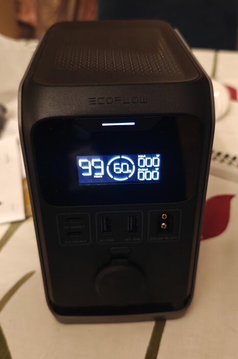 Bärbar batterigenerator med digital display, visar 99 timmar driftstid och 60% batterikapacitet kvar. Används för att driva en kyl utan solenergi.