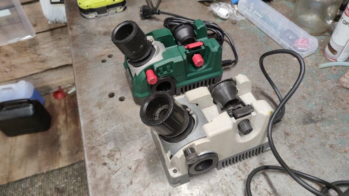 Två borrslipmaskiner på en arbetsbänk, en grön Parkside och en grå, med sladdar synliga och omgivna av verktyg.