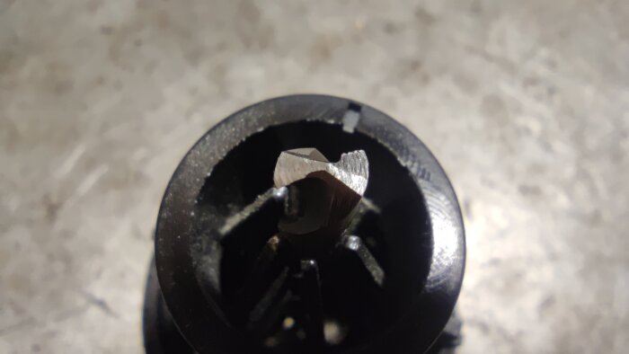 Närbild av en borr fastsatt i en borrslipmaskins chuck, använd som referens för att jämföra slipningsprecision och passform i verktyget.