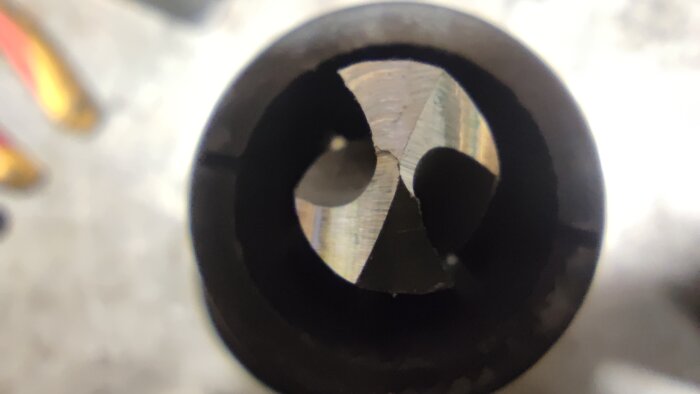 Närbild av en borr i en chuck, visande skärens vinkel och position för borrslipning.