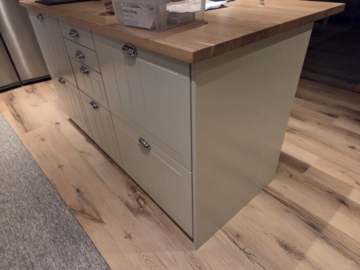 Köksö med träbänkskiva och nyligen sprutmålade luckor och täcksidor i MDF, stående på trägolv.