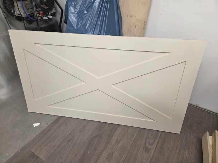 Målade MDF-täcksidor för köksö under torkning, med enkel geometrisk design och slät yta efter slipning och skrapning.