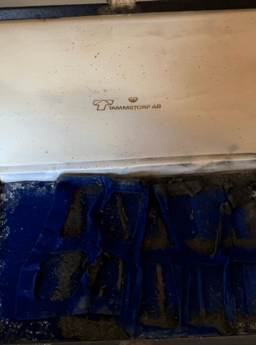 Insida av väska med blå sammet och etiketten "Tammstorp AB" synlig.