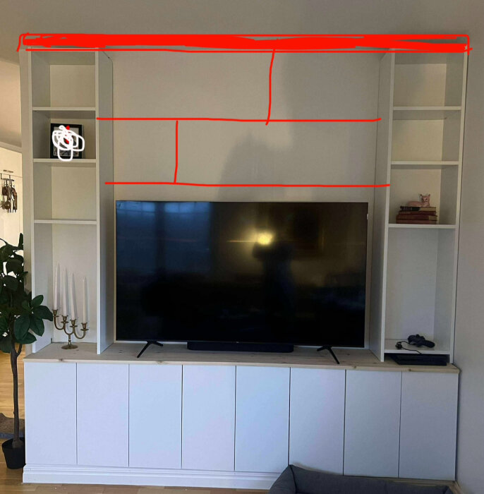 TV-möbel under konstruktion med Ikea-stommar, markerade linjer för planering av inbyggd TV och hyllor.