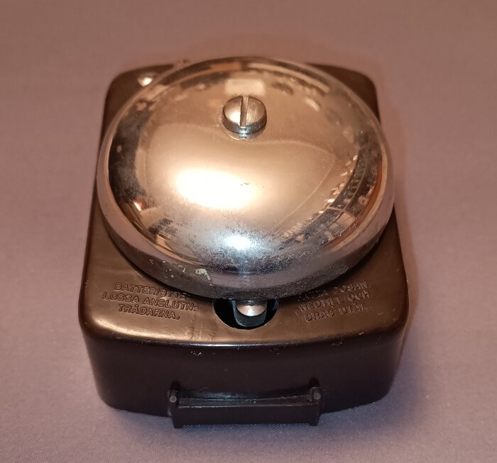 Ringklocka i bakelit från Rapid Isaberg med metallklocka på toppen.