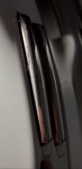 Närbild av fuktsensorer i en torktumlare, reflekterande metalliska ytor, användes för att adressera torkproblem genom rengöring med avkalkning.