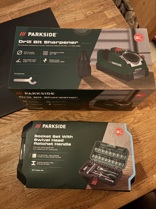 Parkside borrslipmaskin och hylsnyckelsats med svängbart spärrskaft på ett träbord.