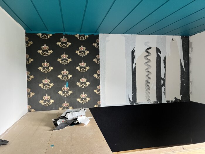 Svart mönstrad tapet rivs ner från en vägg, blottar vit bakgrund. Teal tak ovanför. Svart yta markerar rum i bollhav.