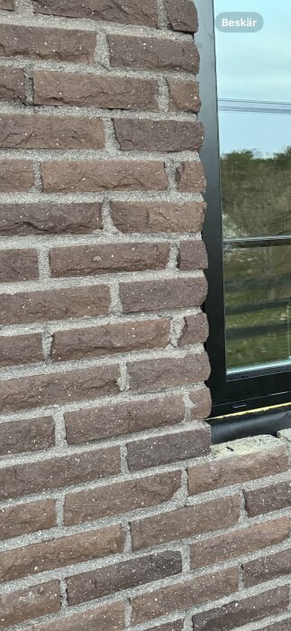 Fasad av mexitegel med mörkare murbruk mellan tegelstenarna.