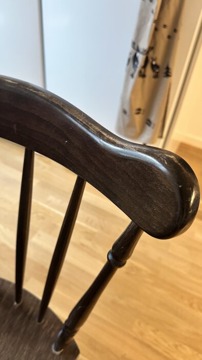 Brun trästol med rundad rygg och släta ytor, del av en fråga om att förnya möbler.