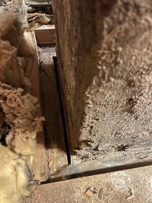 Springa mellan murstock och träregel på kallvind med isolering vid sidorna.