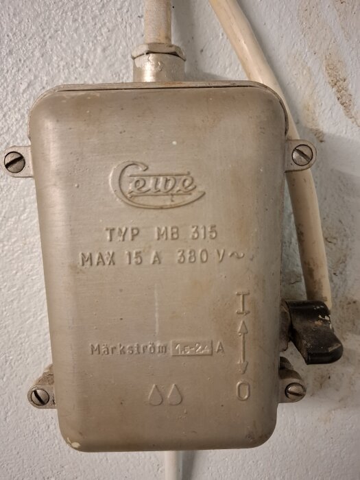 Anslutningsdosa typ MB 315, max 15A, 380V fäst på en vägg med vita kablar.