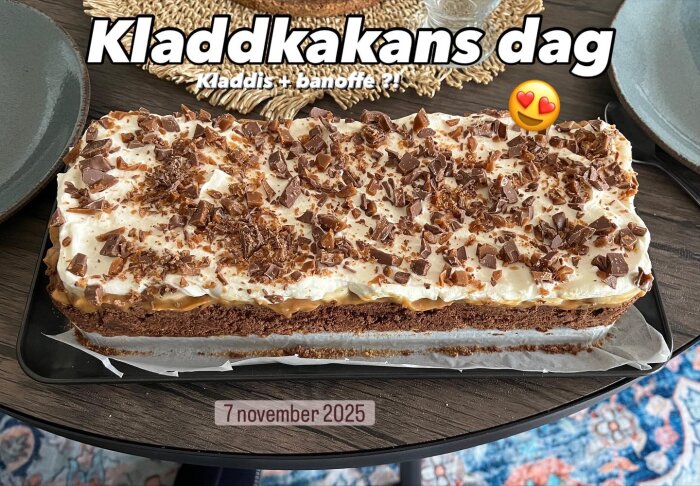 En kladdkaka med banoffee-touch, toppad med grädde och hackad dajm, placerad på ett bord med texten "Kladdkakans dag" ovanpå.