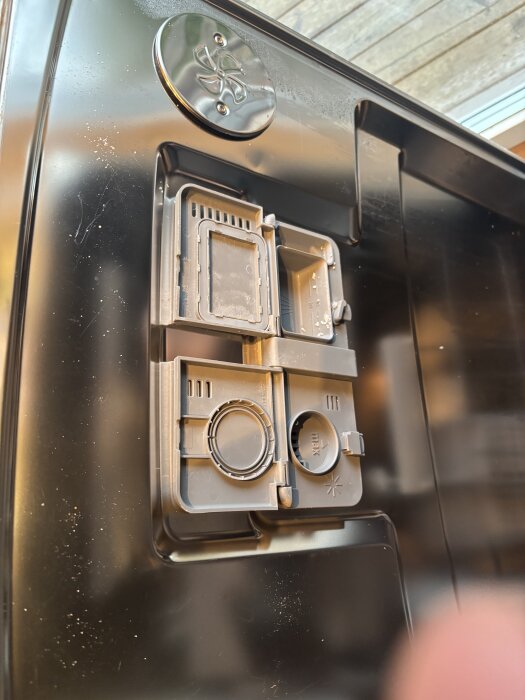 Diskmaskinens insida med bild av diskmedelsfack och filter, diskuteras i inlägget om sköljproblem och diskmedelsrester i Asko diskmaskin.