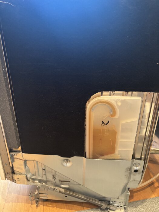 Baksidan av en öppen diskmaskin med en synlig anslutning och sladdar, del av ett felsökningsprojekt.