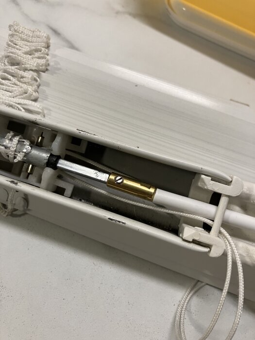 Vridstång och hylsa med låsskruv monterad på en persienn med flexvajer.