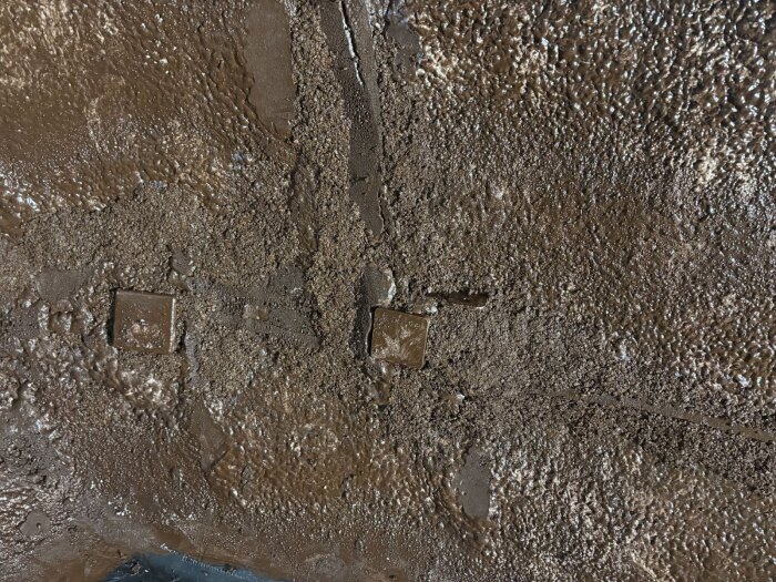 Brun, ojämn yta på väggarna i en husvagn, täckt med en blandning av kork och silikonmassa för isolering och ytförbättring.