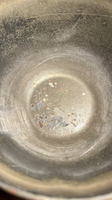 Insidan av en gjutjärns-tekanna med fläckar av rost och beläggningar.