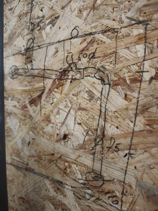 Handritad VVS-skiss på spånskiva visar rördragning mellan dusch, handfat och toalett med måttangivelser och justeringar.