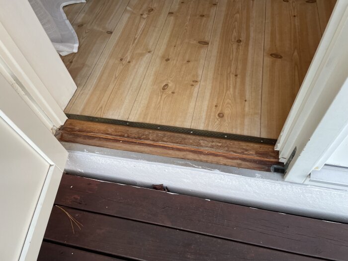 Tröskel vid altandörr med trä- och golvdetaljer, saknade plåt nämnd av besiktningsman.