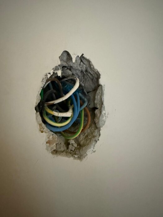 Kablar bakom ett öppet doslock, inlagda direkt i mur eller puts, utan dosa, vid ett tak.