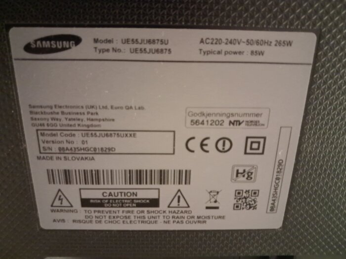 Etikett på baksidan av Samsung TV UE55JU6875U med serienummer och tillverkningsinformation, visar varningar och specifikationer.