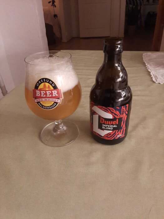 Glas med öl märkt "Øresund Beer and Whisky" och flaska Duvel Imperial Blond på ett bord.