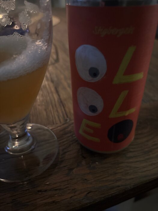 Öl från Stigberget och ett glas med skummande dryck på ett bord.