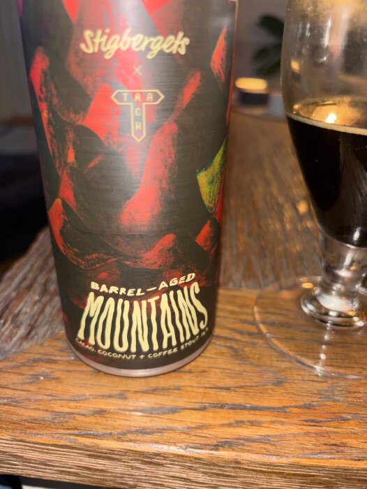 Stigbergets Barrel-Aged Mountains stoutflaska och glas på träbord.