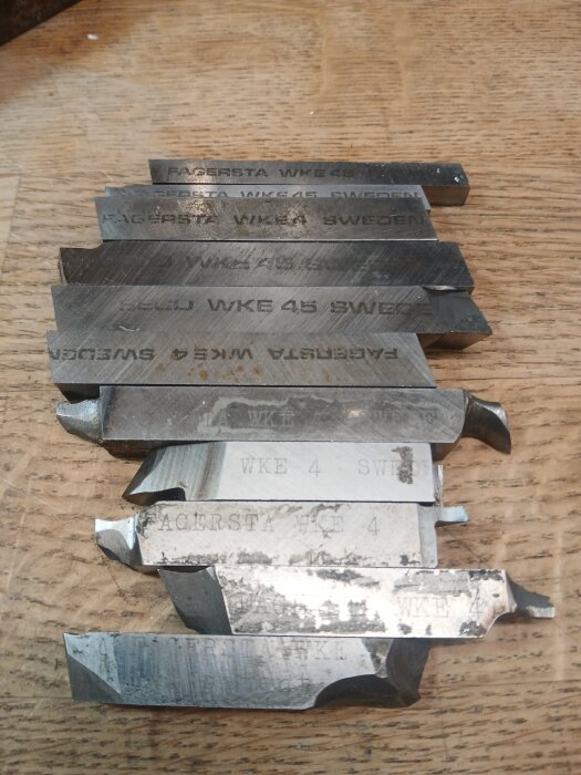 HSS-bitar av metall med märkningen "Fagersta WKE4" ligger staplade på ett bord.