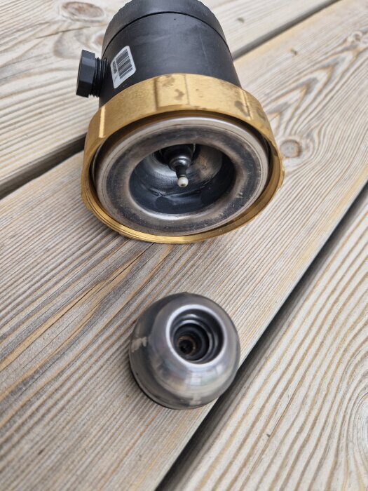 Motor och pumphjul från en cirkulationspump, placerade på en trall, med synliga keramiklager och hölje i metall och plast.