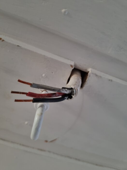 Kablage från tak med tre oskyddade ledningar för byte av taklampa från 70-talet.