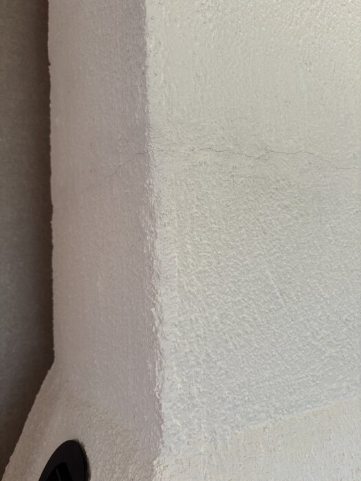 Spricka i murbruket på en inbyggd kamin, synlig på höger sida av strukturen.