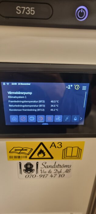Display på värmepump S735 med temperaturvärden och varningssymboler. Telefonnummer och logotyp för Sandströms VVS & Dyk AB syns.