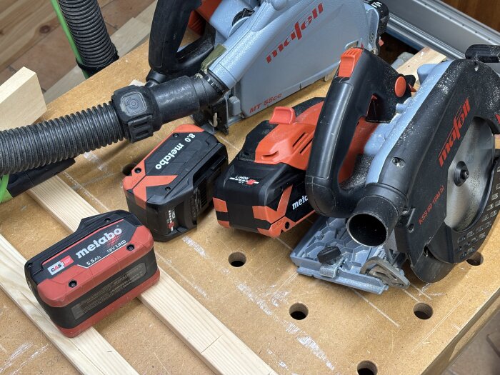 Cirkelsåg och batterier från Metabo och Mafell på en arbetsbänk i träverkstad.