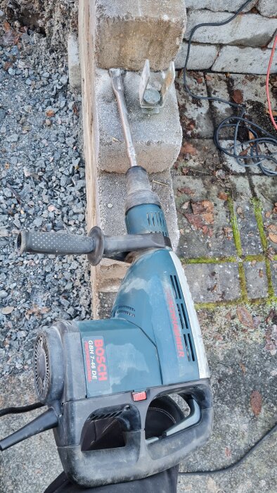 Borrhammare av märket Bosch GBH 7-46 DE påbörjar rivning av betongmurar med synliga stenar och en plattborr i bild.