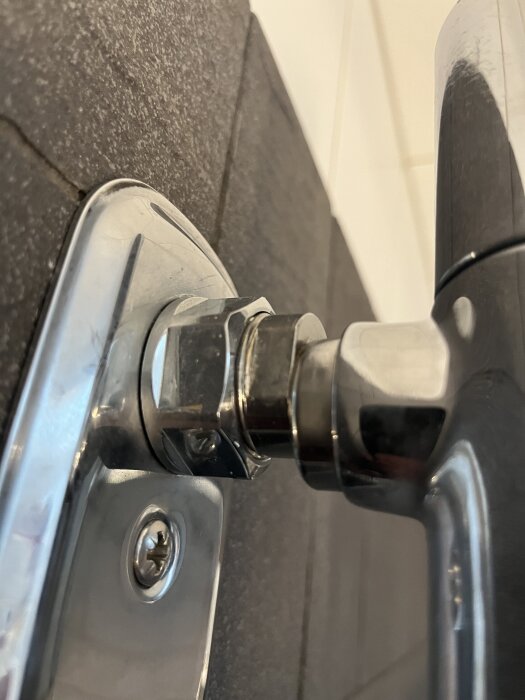 Duschblandare med adapter och mutter fastsatta på kaklad vägg, inklusive insexskruvdetalj, i ett badrum.