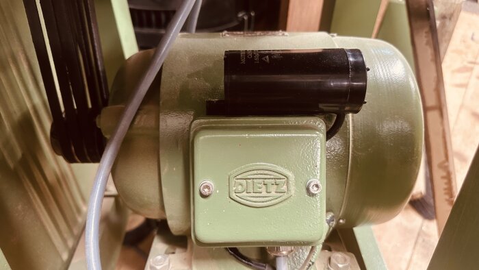 Grön motor med ny svart kondensator monterad på en vintage Ulmia tallriksslip, märkplatta med "DIETZ".